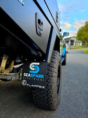 Custom printed Flappies mudflap fitted to a 4WD ute with off-road tyres in an outdoor Australian setting
